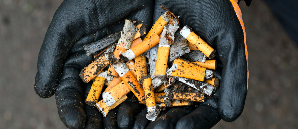 Händer håller fimpar och snus