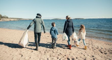 En familj plockar skräp på en strand. Foto: Sanna Holm